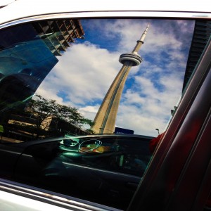 the CN Tower reflected off a car window in downtown Toronto, Ontario, Canada