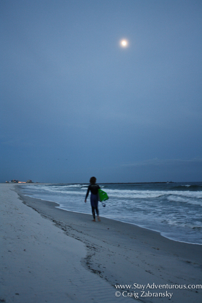 surfer under moonlight on the gulf coast of alabama in orange beach