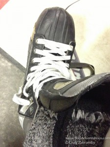 lacing up ice skates to head out on herb brooks arena in lake placid, new york