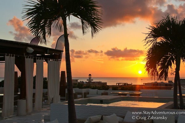 the sunrise in playa del carmen warms the rooftop of the palm at playa