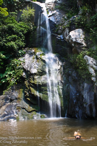 a women swiming at the waterfall in yelapa, jalisco, outside of puerto vallarta