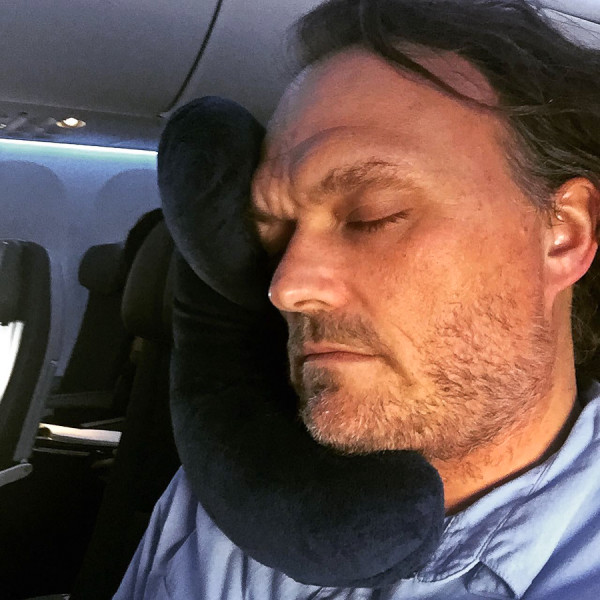 J-pillow being used on airplane sleeping