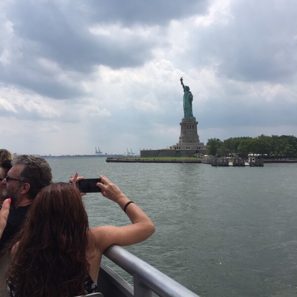 taking a photo of the statue of liberty from the Liberty Cruise part of Top View NYC Tours 