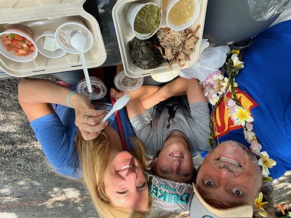 family eating take out poi and pork on jeep hood oahu hawaii