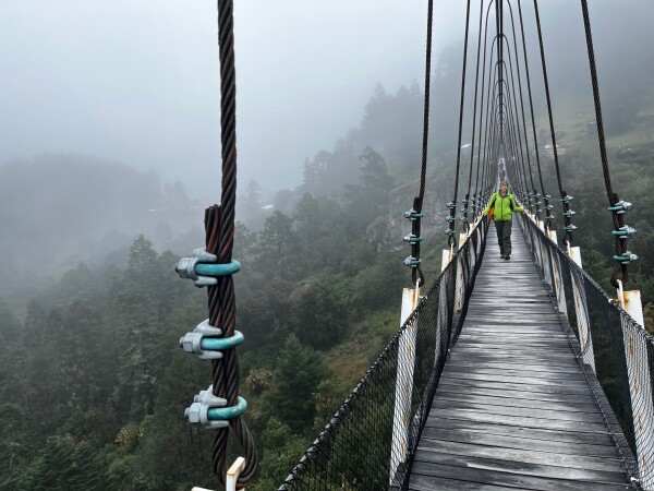 walking across the suspension birdge at benito juarez in sierra norte, oaxaca, mexico