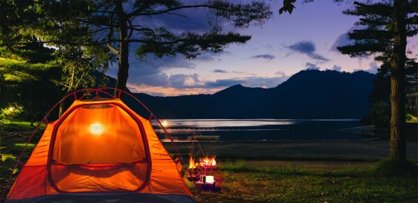 camping at night at a lake with solight